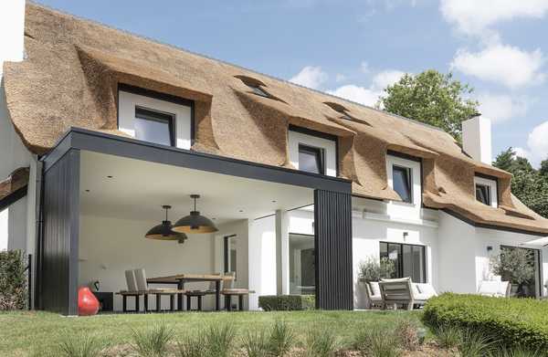 Un architecte d’intérieur et un paysagiste aménage la terrase, la pool house et la piscine à débordement d'une ville à Annecy.