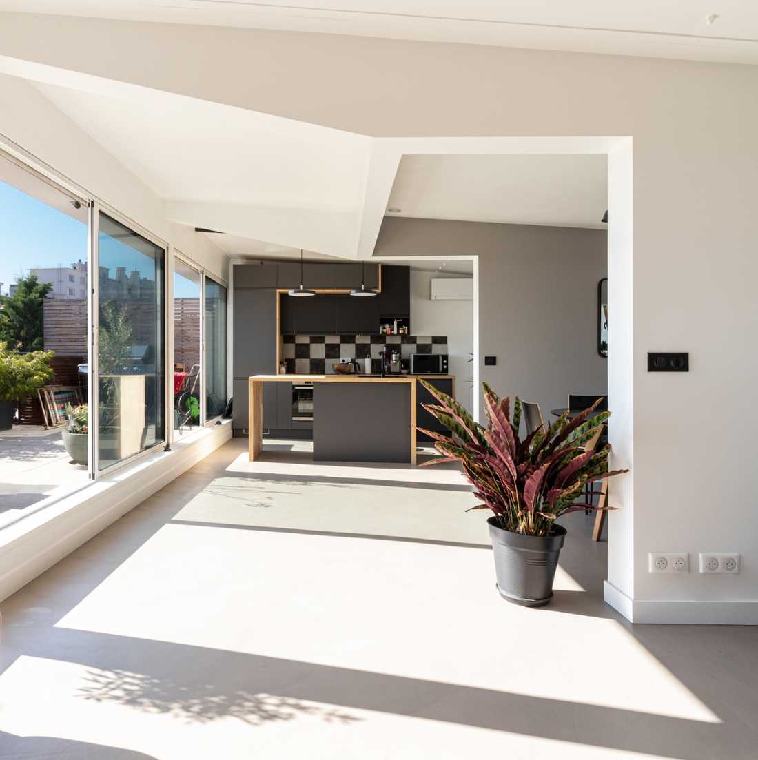 Aménagement duplex immeuble années 70 - cuisine vue depuis le séjour avec sol en béton Marius Aurenti